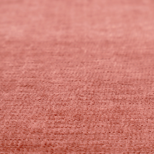 A dusty rose or salmon-pink fabric with a soft, multi-directional texture. While it maintains a subtle horizontal grain, the weave is more flecked and feathered than previous styles, creating a plush, velvet-like surface with organic light-catching highlights.