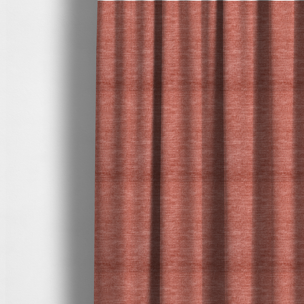 The fabric used to create these made-to-measure curtains is a dusty rose or salmon-pink fabric with a soft, multi-directional texture. While it maintains a subtle horizontal grain, the weave is more flecked and feathered than previous styles, creating a plush, velvet-like surface with organic light-catching highlights.