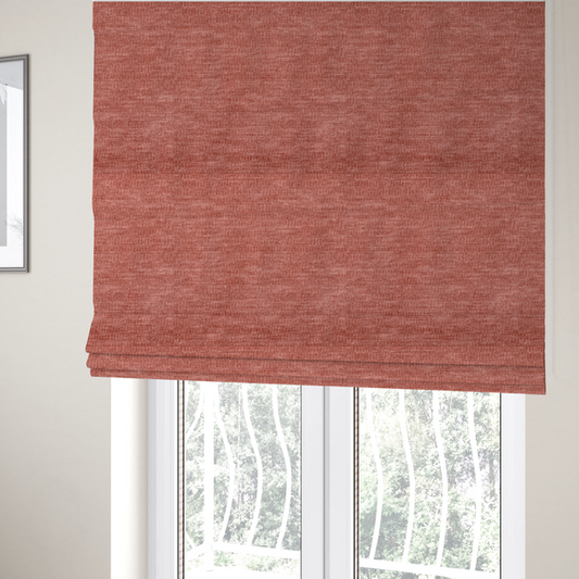 The fabric used to create these Roman blinds is a dusty rose or salmon-pink fabric with a soft, multi-directional texture. While it maintains a subtle horizontal grain, the weave is more flecked and feathered than previous styles, creating a plush, velvet-like surface with organic light-catching highlights.