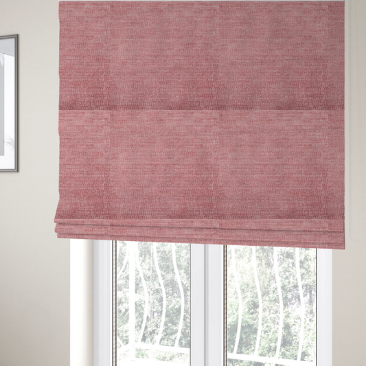 The fabric used to create these Roman blinds is a vibrant mauve-pink or raspberry-toned fabric featuring a dense, horizontal corded texture. The soft, plush weave creates a uniform linear pattern with a subtle velvety sheen that catches the light along each ridge.