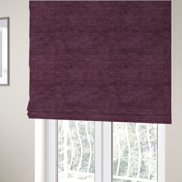 The fabric used to create these Roman blinds is a deep plum or dark berry purple fabric with a rich, textured weave. It features a subtle horizontal grain combined with a soft, mottled pile that creates depth through varying shades of purple and wine, resulting in a plush and sophisticated finish.