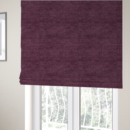 The fabric used to create these Roman blinds is a deep plum or dark berry purple fabric with a rich, textured weave. It features a subtle horizontal grain combined with a soft, mottled pile that creates depth through varying shades of purple and wine, resulting in a plush and sophisticated finish.