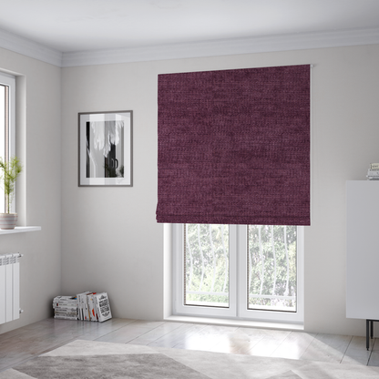 The fabric used to create these Roman blinds is a deep plum or dark berry purple fabric with a rich, textured weave. It features a subtle horizontal grain combined with a soft, mottled pile that creates depth through varying shades of purple and wine, resulting in a plush and sophisticated finish.