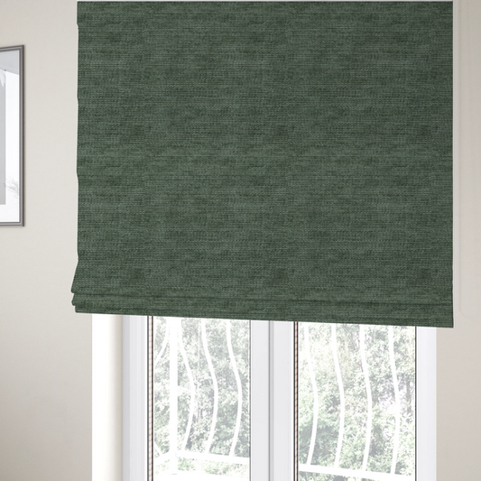 The fabric used to create these Roman blinds is a forest green fabric with a dense horizontal ribbed texture. The weave features a soft, velvety pile that creates a subtle play of light and shadow across the linear ridges, giving the material a rich, organic feel.