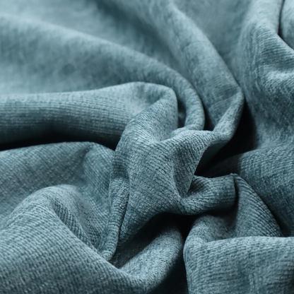 a teal or dusty blue fabric with a soft, weathered texture. The weave features a subtle horizontal grain with a plush, multi-tonal pile that blends shades of slate and ocean blue for a rich, tactile appearance.