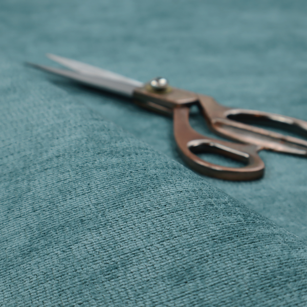 A deep peacock blue fabric with a structured horizontal corded texture. The plush, velvety ridges create a dense linear pattern, offering a sophisticated play of light and shadow with a soft, durable finish.