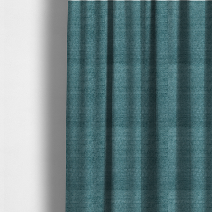 The fabric used to create these made-to-measure curtains is a deep peacock blue fabric with a structured horizontal corded texture. The plush, velvety ridges create a dense linear pattern, offering a sophisticated play of light and shadow with a soft, durable finish.