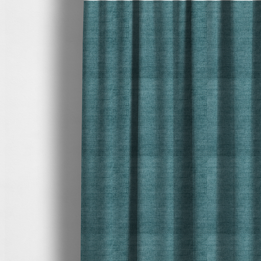 The fabric used to create these made-to-measure curtains is a deep peacock blue fabric with a structured horizontal corded texture. The plush, velvety ridges create a dense linear pattern, offering a sophisticated play of light and shadow with a soft, durable finish.