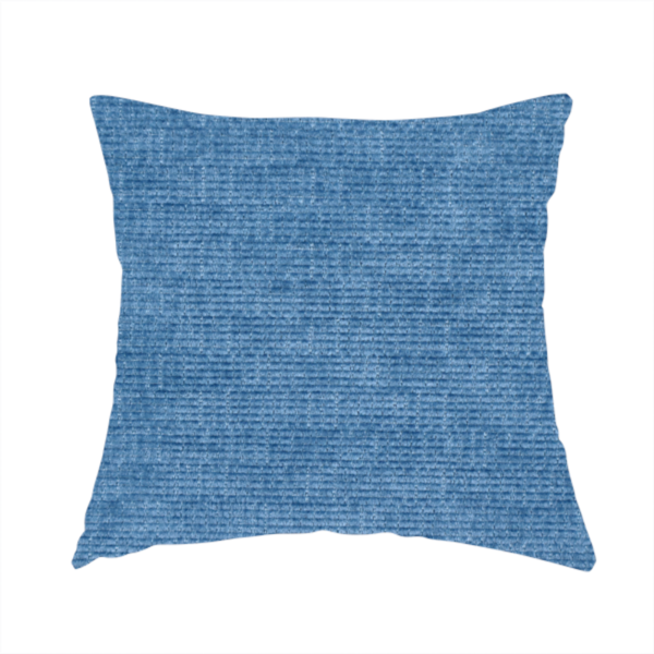 The fabric used to create these handmade cushions is a vibrant mid-blue or cornflower blue fabric featuring a dense horizontal corded texture. The weave has a soft, plush finish with a subtle velvety sheen that creates light-catching highlights across the uniform linear ridges.