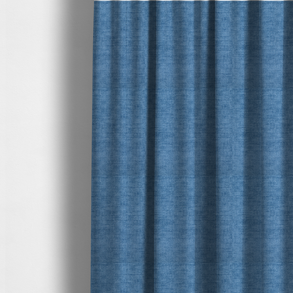 The fabric used to create these made-to-measure curtains is a vibrant mid-blue or cornflower blue fabric featuring a dense horizontal corded texture. The weave has a soft, plush finish with a subtle velvety sheen that creates light-catching highlights across the uniform linear ridges.
