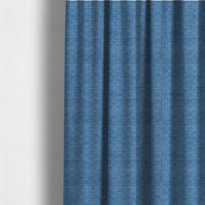 The fabric used to create these made-to-measure curtains is a vibrant mid-blue or cornflower blue fabric featuring a dense horizontal corded texture. The weave has a soft, plush finish with a subtle velvety sheen that creates light-catching highlights across the uniform linear ridges.