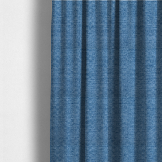The fabric used to create these made-to-measure curtains is a vibrant mid-blue or cornflower blue fabric featuring a dense horizontal corded texture. The weave has a soft, plush finish with a subtle velvety sheen that creates light-catching highlights across the uniform linear ridges.