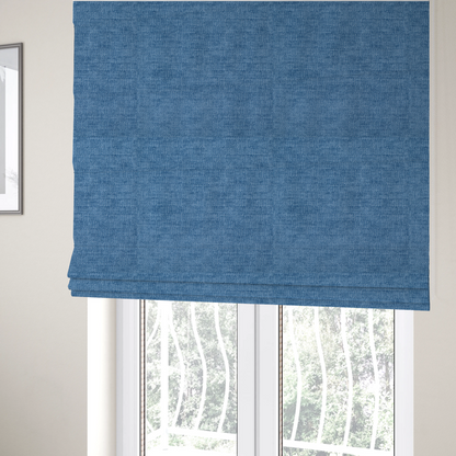 The fabric used to create these Roman blinds is a vibrant mid-blue or cornflower blue fabric featuring a dense horizontal corded texture. The weave has a soft, plush finish with a subtle velvety sheen that creates light-catching highlights across the uniform linear ridges.