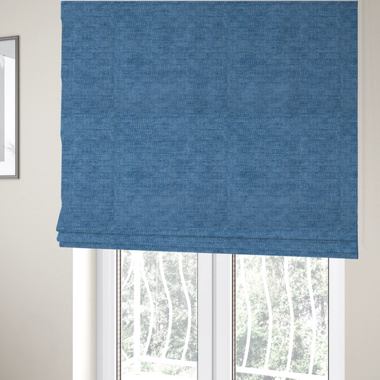 The fabric used to create these Roman blinds is a vibrant mid-blue or cornflower blue fabric featuring a dense horizontal corded texture. The weave has a soft, plush finish with a subtle velvety sheen that creates light-catching highlights across the uniform linear ridges.