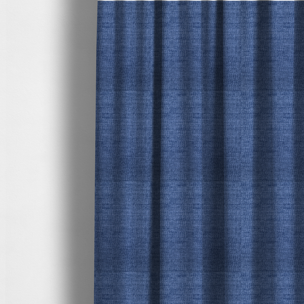 The fabric used to create these made-to-measure curtains is a deep royal blue or indigo fabric with a dense horizontal ribbed texture. The weave features a soft, plush pile that creates a multi-tonal effect with rich shadows and mid-tone blue highlights across the linear ridges.