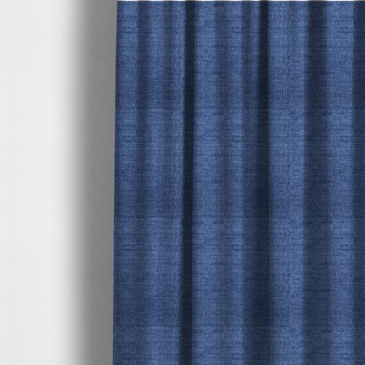 The fabric used to create these made-to-measure curtains is a deep royal blue or indigo fabric with a dense horizontal ribbed texture. The weave features a soft, plush pile that creates a multi-tonal effect with rich shadows and mid-tone blue highlights across the linear ridges.