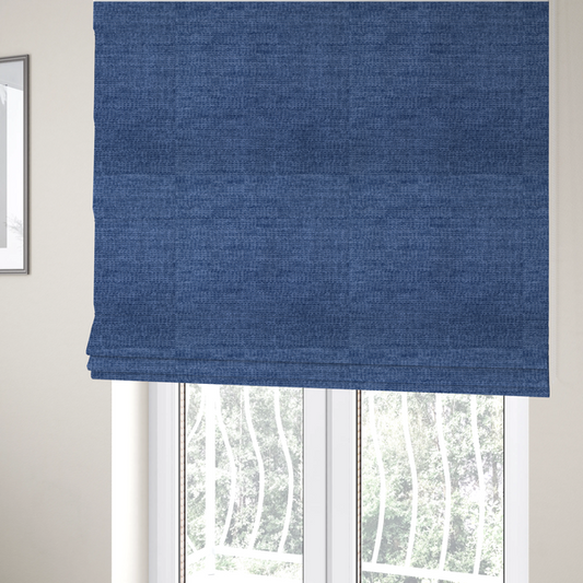 The fabric used to create these Roman blinds is a deep royal blue or indigo fabric with a dense horizontal ribbed texture. The weave features a soft, plush pile that creates a multi-tonal effect with rich shadows and mid-tone blue highlights across the linear ridges.