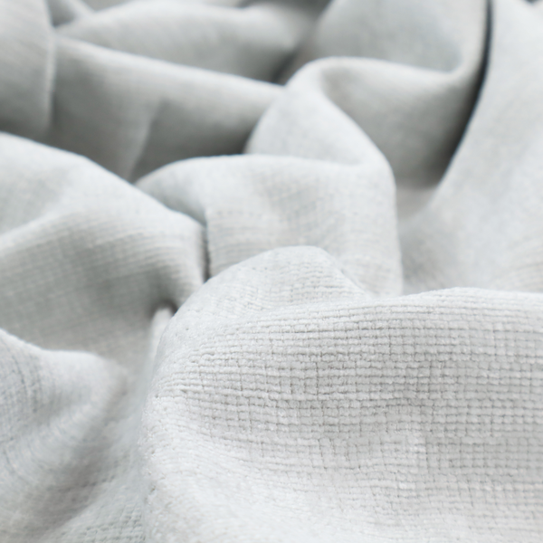 A cool, silver-white fabric with a soft, uniform horizontal ribbed texture. The material features a plush, chenille-like pile that provides a subtle, velvety sheen, catching the light across the fine linear ridges for a clean and modern look.