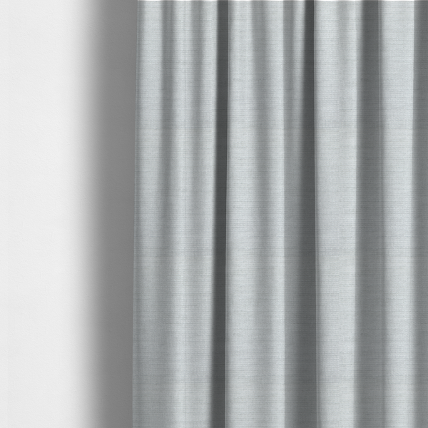 The fabric used to create these made-to-measure curtains is a cool, silver-white fabric with a soft, uniform horizontal ribbed texture. The material features a plush, chenille-like pile that provides a subtle, velvety sheen, catching the light across the fine linear ridges for a clean and modern look.