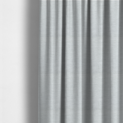 The fabric used to create these made-to-measure curtains is a cool, silver-white fabric with a soft, uniform horizontal ribbed texture. The material features a plush, chenille-like pile that provides a subtle, velvety sheen, catching the light across the fine linear ridges for a clean and modern look.