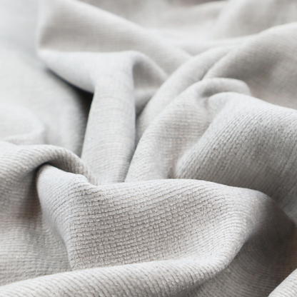 A light grey fabric with a soft, uniform horizontal ribbed texture. The weave has a plush, velvety pile that creates subtle shadows and highlights across the linear ridges, providing a clean, modern aesthetic with a tactile feel.