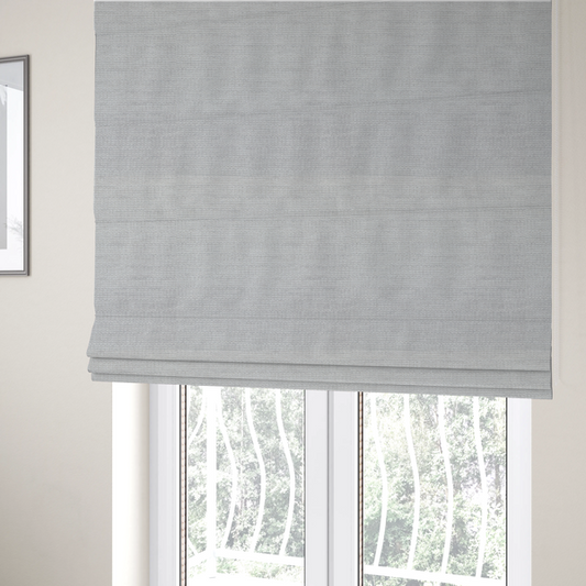 The fabric used to create these Roman blinds is a light grey fabric with a soft, uniform horizontal ribbed texture. The weave has a plush, velvety pile that creates subtle shadows and highlights across the linear ridges, providing a clean, modern aesthetic with a tactile feel.