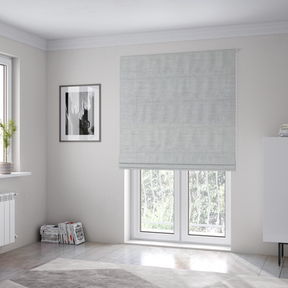 The fabric used to create these Roman blinds is a light grey fabric with a soft, uniform horizontal ribbed texture. The weave has a plush, velvety pile that creates subtle shadows and highlights across the linear ridges, providing a clean, modern aesthetic with a tactile feel.