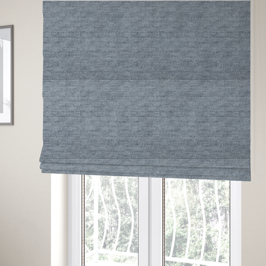 The fabric used to create these Roman blinds is a slate grey fabric with a dense horizontal ribbed texture. The material features a plush, velvety pile with subtle mottled highlights, creating a rich, tactile surface that offers both depth and a modern, clean aesthetic.