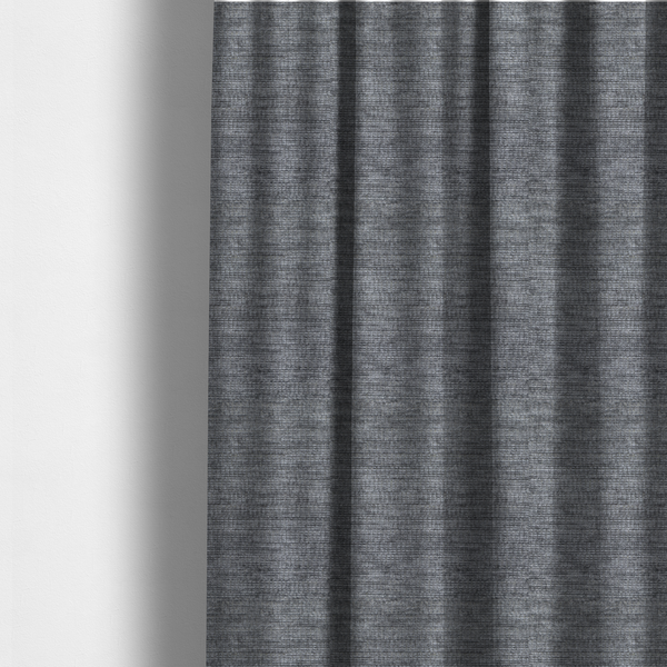 The fabric used to create these made-to-measure curtains is a dark charcoal grey fabric with a dense horizontal ribbed texture. The weave features a soft, plush pile with subtle weathered variations, creating a multi-tonal smoky effect that adds depth and a sophisticated matte finish.