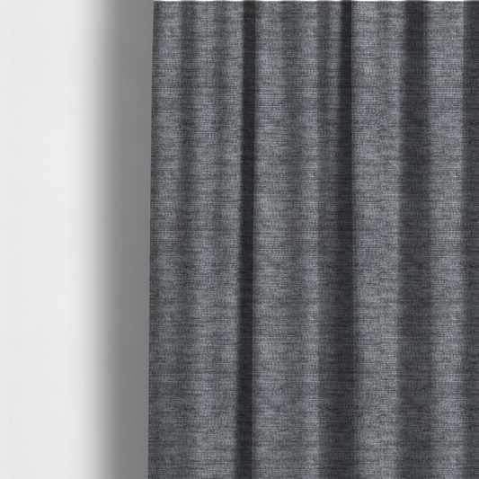 The fabric used to create these made-to-measure curtains is a dark charcoal grey fabric with a dense horizontal ribbed texture. The weave features a soft, plush pile with subtle weathered variations, creating a multi-tonal smoky effect that adds depth and a sophisticated matte finish.