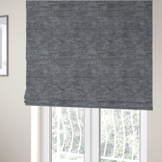 The fabric used to create these Roman blinds is a dark charcoal grey fabric with a dense horizontal ribbed texture. The weave features a soft, plush pile with subtle weathered variations, creating a multi-tonal smoky effect that adds depth and a sophisticated matte finish.