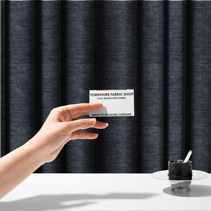 The fabric used to create these made-to-measure curtains is a deep navy-charcoal fabric with a dense horizontal ribbed texture. The material has a soft, plush pile that creates a subtle multi-tonal effect, blending dark midnight blue and charcoal grey tones with a durable matte finish.