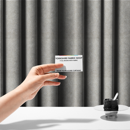 The fabric used to create these made-to-measure curtains is a warm off-white or light oatmeal shade. The textile features a dense, multi-tonal basket weave pattern with visible interlacing threads in cream and soft beige, creating a textured, linen-look surface.