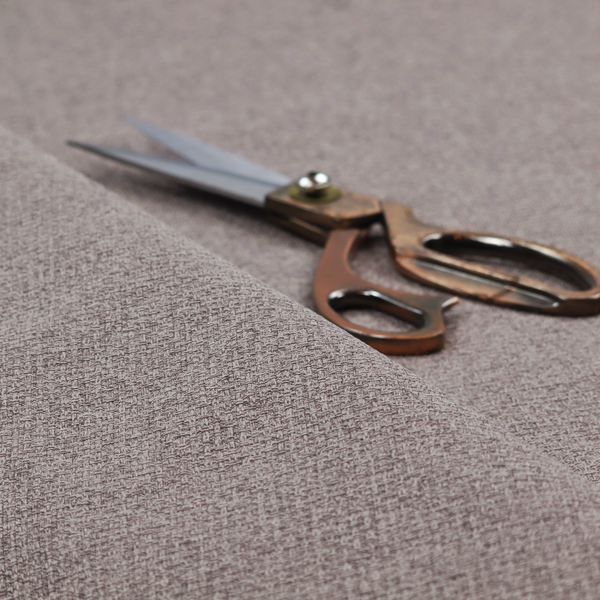 An upholstery fabric in a sophisticated mink or warm grey shade. The textile features a tight, multi-tonal weave with interlacing threads of deep taupe, charcoal, and soft brown, creating a rich, textured surface with a matte finish.