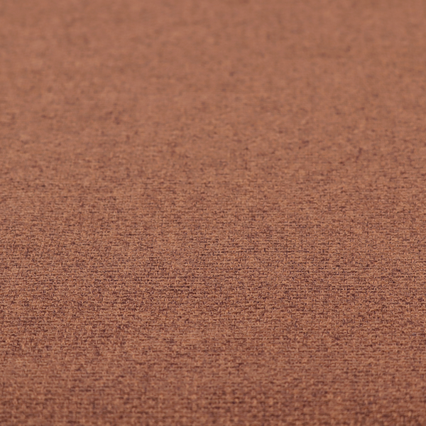 An upholstery fabric in a warm terracotta or burnt orange shade. The textile features a multi-tonal basket weave with interlacing copper and dark brown threads, creating a rich, textured linen-look surface with an earthy, matte finish.