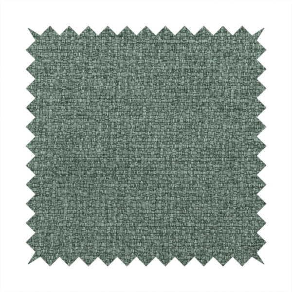 An upholstery fabric in a serene seafoam or muted teal shade. The textile features a dense, multi-tonal weave with interlacing threads of dusty blue-green and dark charcoal, creating a textured, linen-look surface with a matte finish.