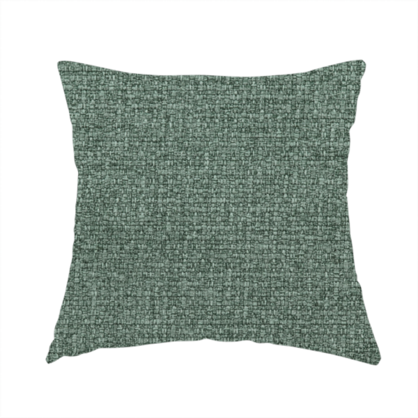 The fabric used to create this handmade cushion is a upholstery fabric in a serene seafoam or muted teal shade. The textile features a dense, multi-tonal weave with interlacing threads of dusty blue-green and dark charcoal, creating a textured, linen-look surface with a matte finish.