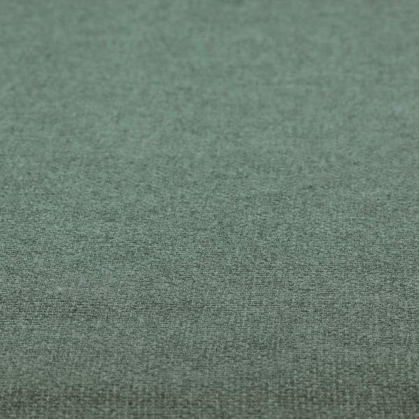 An upholstery fabric in a serene seafoam or muted teal shade. The textile features a dense, multi-tonal weave with interlacing threads of dusty blue-green and dark charcoal, creating a textured, linen-look surface with a matte finish.