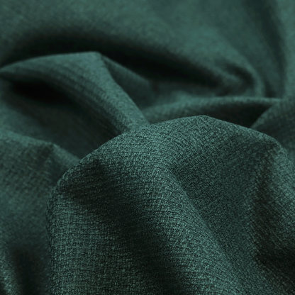 An upholstery fabric in a deep forest or emerald green shade. The textile features a dense, multi-tonal weave with interlaced threads of dark teal and charcoal, creating a rich, textured linen-look surface with a sophisticated matte finish.