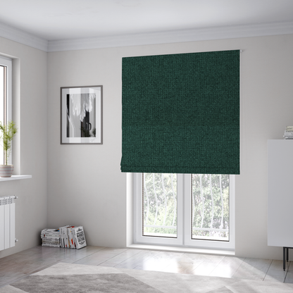 The fabric used to create these Roman blinds is a upholstery fabric in a deep forest or emerald green shade. The textile features a dense, multi-tonal weave with interlaced threads of dark teal and charcoal, creating a rich, textured linen-look surface with a sophisticated matte finish.