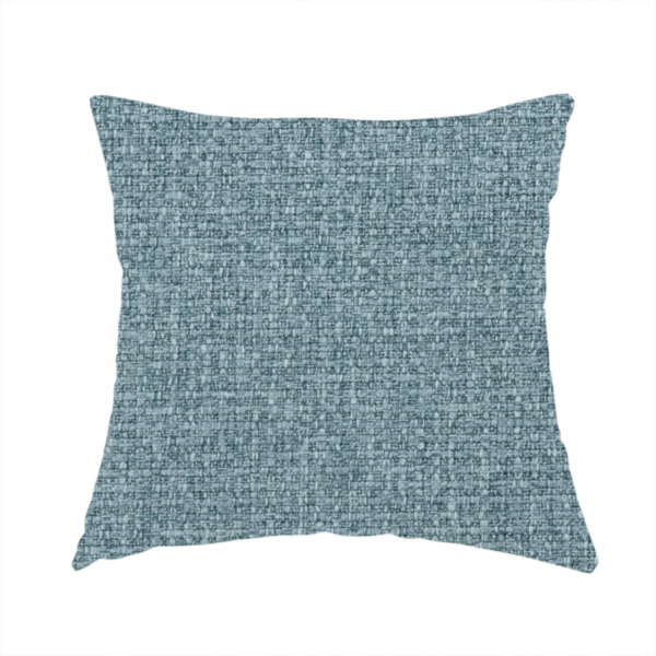 The fabric used to create these handmade cushions is a upholstery fabric in a soft slate blue or dusty denim shade. The textile features a dense, multi-tonal basket weave with interlaced threads of sky blue, muted grey, and charcoal, creating a textured, linen-look surface with a matte finish.
