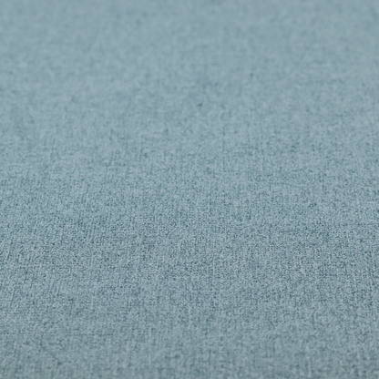 An upholstery fabric in a soft slate blue or dusty denim shade. The textile features a dense, multi-tonal basket weave with interlaced threads of sky blue, muted grey, and charcoal, creating a textured, linen-look surface with a matte finish.