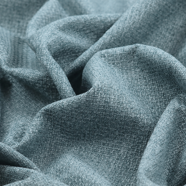 An upholstery fabric in a soft slate blue or dusty denim shade. The textile features a dense, multi-tonal basket weave with interlaced threads of sky blue, muted grey, and charcoal, creating a textured, linen-look surface with a matte finish.
