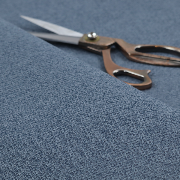 An upholstery fabric in a classic navy or denim blue. The textile features a dense, multi-tonal weave with interlacing threads of royal blue, charcoal, and soft grey, creating a rich, textured linen-look surface with a matte finish.