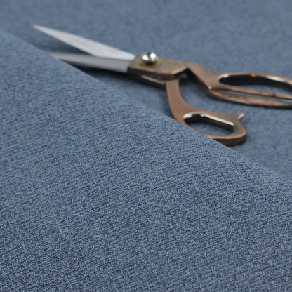 An upholstery fabric in a classic navy or denim blue. The textile features a dense, multi-tonal weave with interlacing threads of royal blue, charcoal, and soft grey, creating a rich, textured linen-look surface with a matte finish.