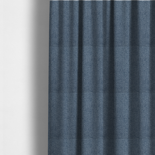 The fabric used to create these made-to-measure curtains is a upholstery fabric in a classic navy or denim blue. The textile features a dense, multi-tonal weave with interlacing threads of royal blue, charcoal, and soft grey, creating a rich, textured linen-look surface with a matte finish.