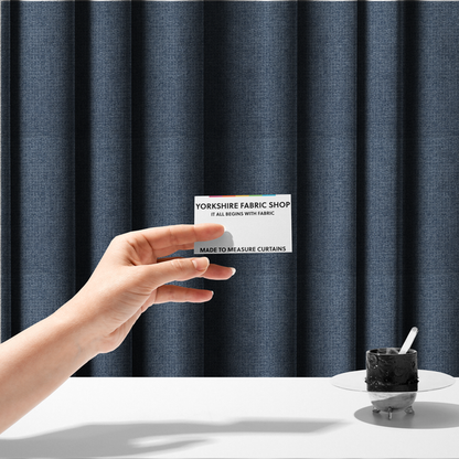 The fabric used to create these made-to-measure curtains is a upholstery fabric in a classic navy or denim blue. The textile features a dense, multi-tonal weave with interlacing threads of royal blue, charcoal, and soft grey, creating a rich, textured linen-look surface with a matte finish.