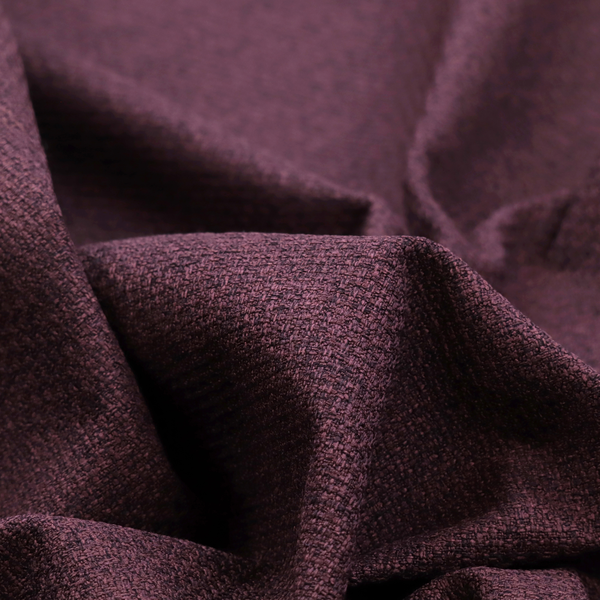 an upholstery fabric in a rich plum or deep burgundy shade. The textile features a dense, multi-tonal weave with interlacing threads of dark purple, berry, and charcoal, creating a textured, linen-look surface with a sophisticated matte finish.