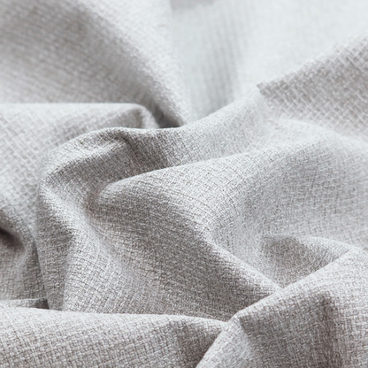 A fabric in a cool-toned light silver or pale grey. The weave features interlaced white and soft grey threads, creating a bright, contemporary textured finish.