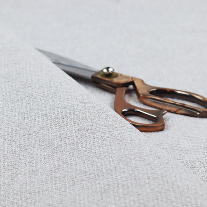 A fabric in a cool-toned light silver or pale grey. The weave features interlaced white and soft grey threads, creating a bright, contemporary textured finish.